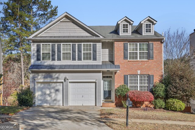 260 Wildcat Lake Dr, Lawrenceville, GA 30043 - view of front of property featuring a standing seam roof, brick siding, an attached garage, driveway, and a metal roof
