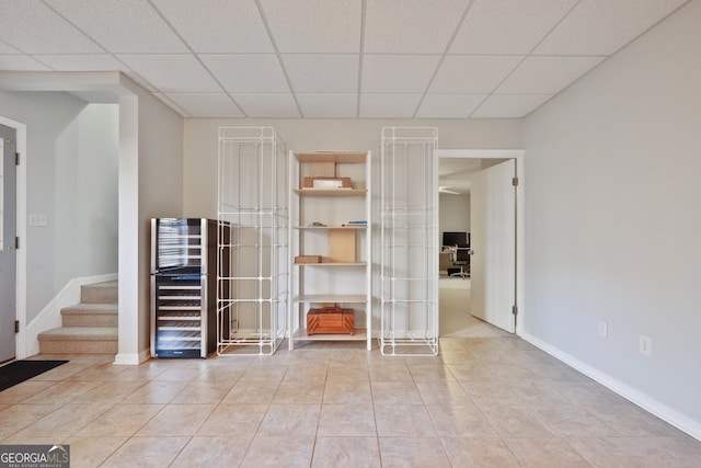 260 Wildcat Lake Dr, Lawrenceville, GA 30043 - tiled spare room with wine cooler, a drop ceiling, and stairs
