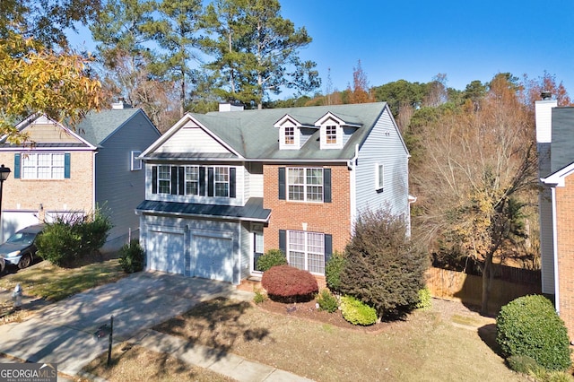 260 Wildcat Lake Dr, Lawrenceville, GA 30043 - traditional-style home featuring driveway, an attached garage, brick siding, a standing seam roof, and a metal roof