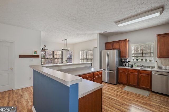 260 Wildcat Lake Dr, Lawrenceville, GA 30043 - kitchen with stainless steel appliances, light wood-style floors, a kitchen island, light countertops, and backsplash