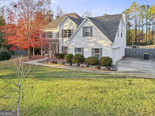 view of front of property featuring a front yard and a garage