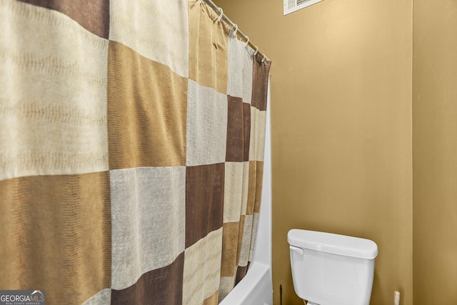 bathroom featuring shower / tub combo with curtain and toilet