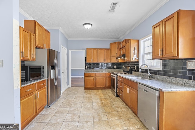 kitchen featuring sink, ornamental molding, stainless steel appliances, and light stone countertops