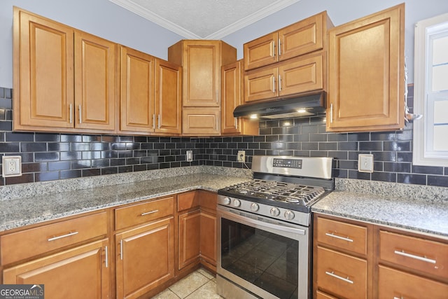 kitchen featuring tasteful backsplash, stainless steel gas range oven, light stone countertops, and plenty of natural light