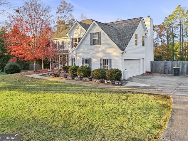 view of front of house featuring a balcony, a front yard, and a garage