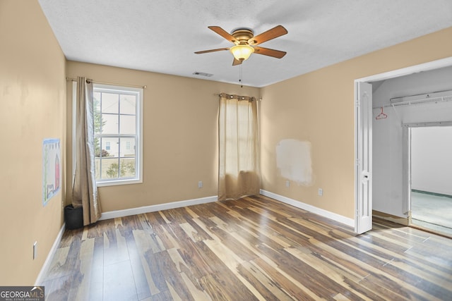 unfurnished bedroom featuring hardwood / wood-style flooring, a textured ceiling, a closet, and ceiling fan