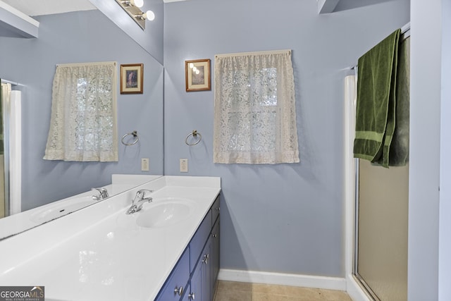 bathroom with a shower with door, vanity, and tile patterned flooring