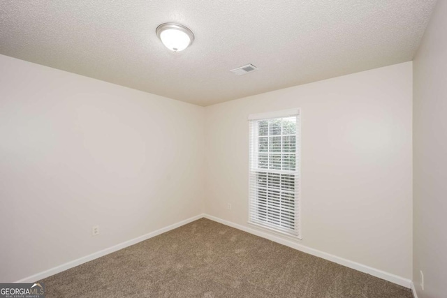 carpeted empty room with a textured ceiling