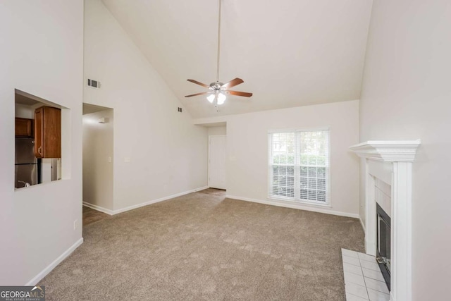 unfurnished living room with ceiling fan, light colored carpet, a tile fireplace, and high vaulted ceiling