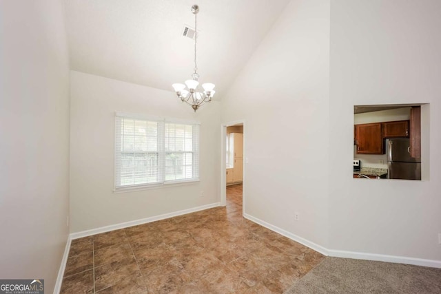 spare room featuring a chandelier and high vaulted ceiling