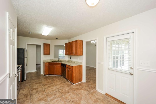 kitchen with light tile patterned flooring, a textured ceiling, stainless steel appliances, and sink