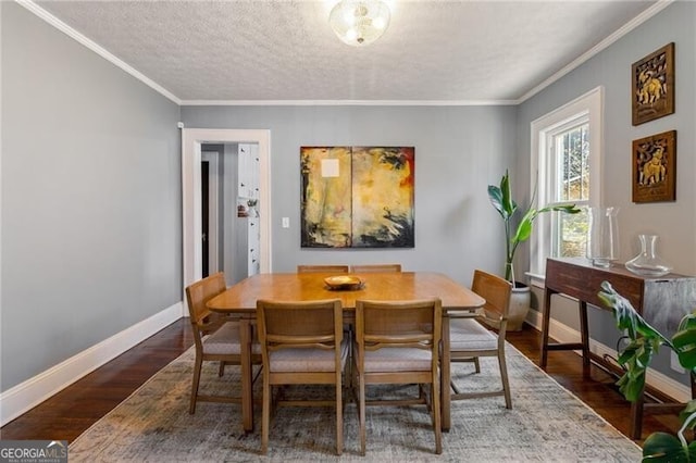 dining room with dark hardwood / wood-style flooring, a textured ceiling, and ornamental molding