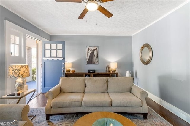 living room featuring a textured ceiling, hardwood / wood-style flooring, and ornamental molding