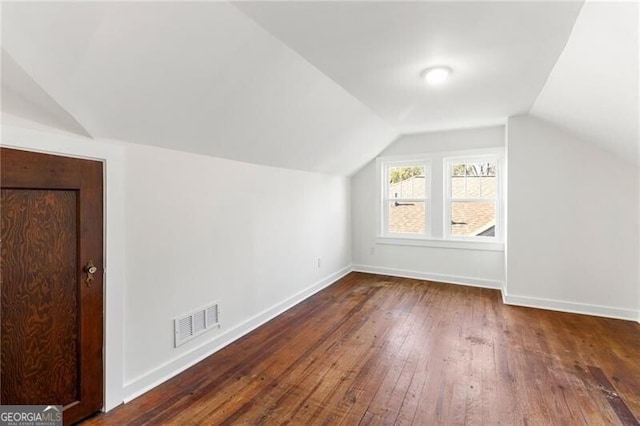 additional living space featuring lofted ceiling and dark wood-type flooring