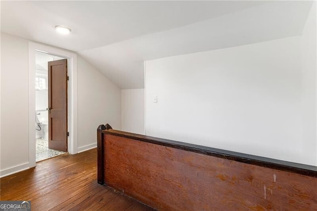 bonus room featuring vaulted ceiling and dark wood-type flooring