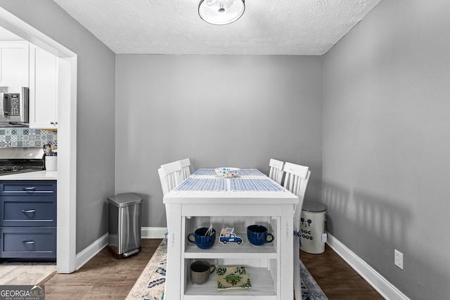 dining space featuring a textured ceiling and light hardwood / wood-style floors