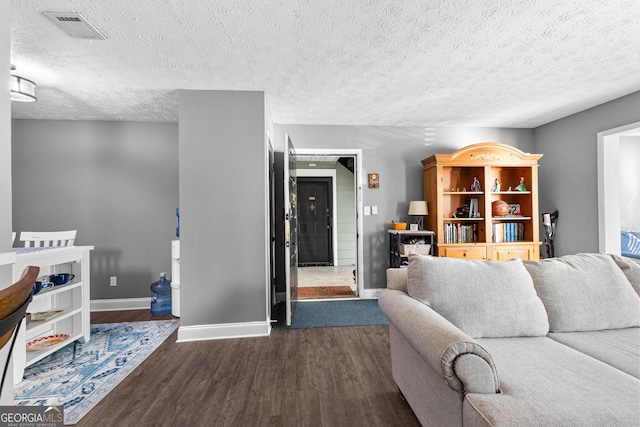 living room with dark hardwood / wood-style flooring and a textured ceiling