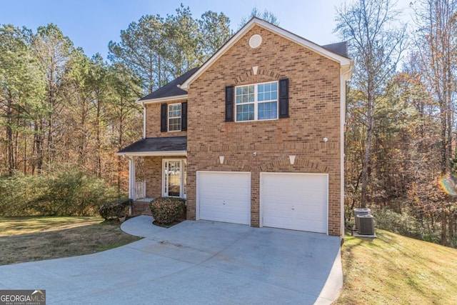 front of property featuring central air condition unit, a front yard, and a garage