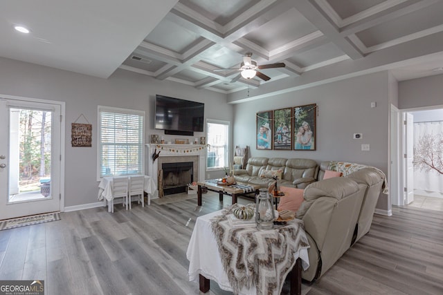 living room featuring ceiling fan, coffered ceiling, beamed ceiling, crown molding, and light wood-type flooring