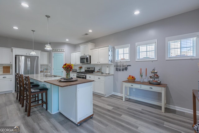 kitchen with white cabinets, plenty of natural light, and stainless steel appliances