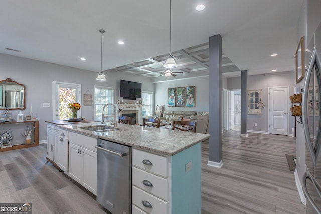 kitchen with a kitchen island with sink, sink, white cabinets, and light hardwood / wood-style flooring