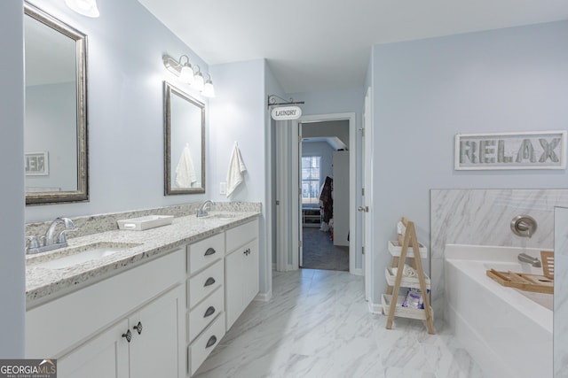 bathroom featuring a washtub and vanity