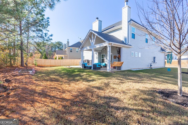 rear view of house featuring a yard, a patio, and an outdoor hangout area