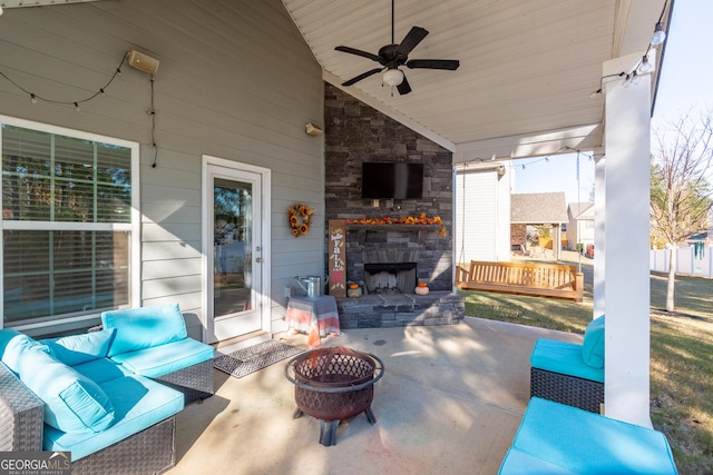 view of patio / terrace with an outdoor living space with a fireplace and ceiling fan