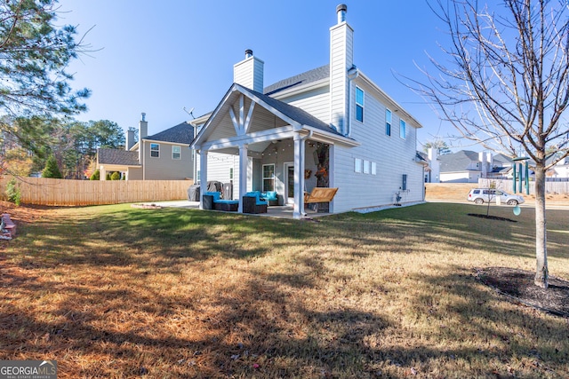 rear view of house featuring a yard and a patio