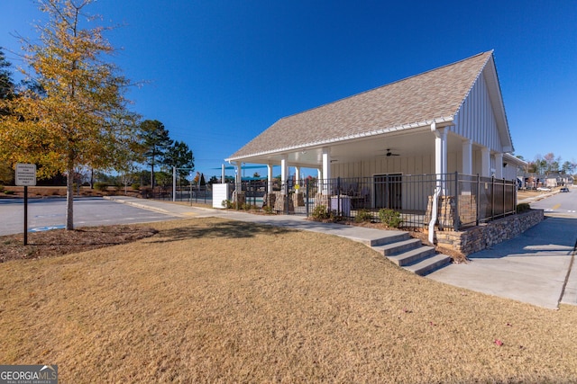 exterior space with ceiling fan and a yard