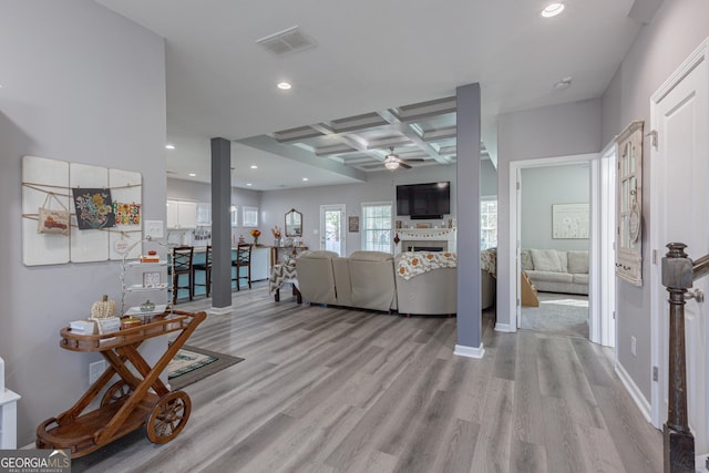 living room featuring coffered ceiling, ceiling fan, beam ceiling, and light hardwood / wood-style flooring