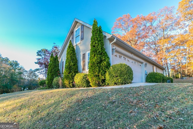 view of side of property with a yard and a garage