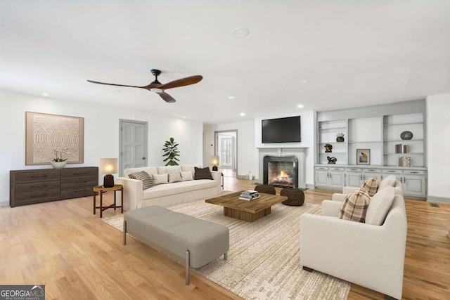 living room featuring ceiling fan and light hardwood / wood-style floors