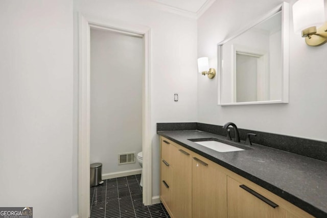 bathroom featuring tile patterned flooring, vanity, ornamental molding, and toilet