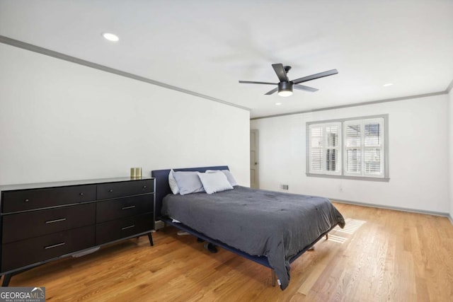 bedroom with crown molding, ceiling fan, and light hardwood / wood-style flooring