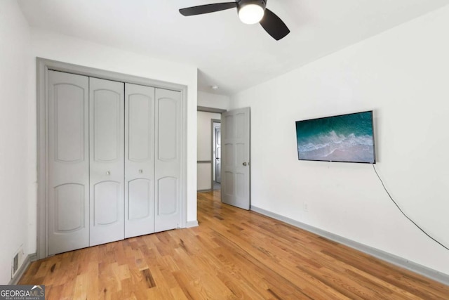 unfurnished bedroom featuring a closet, ceiling fan, and light wood-type flooring