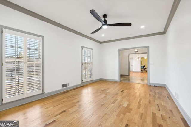 interior space with ceiling fan with notable chandelier, ornamental molding, and light wood-type flooring