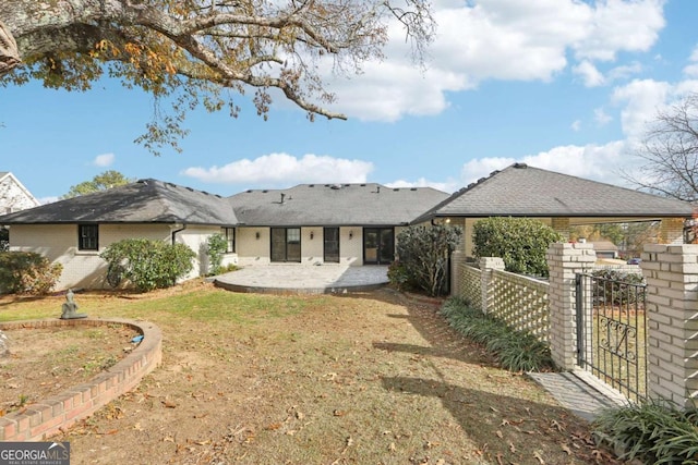 back of property with a lawn and a patio