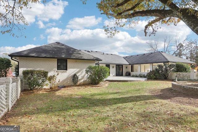 rear view of property featuring a yard and a patio