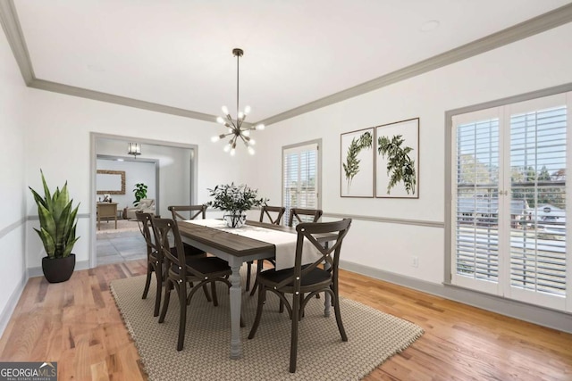 dining room featuring crown molding, light hardwood / wood-style flooring, and a notable chandelier