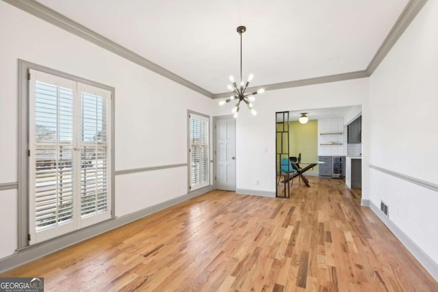 empty room with wine cooler, a notable chandelier, crown molding, and hardwood / wood-style flooring