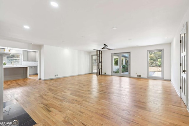 unfurnished living room featuring french doors, ceiling fan, and light wood-type flooring