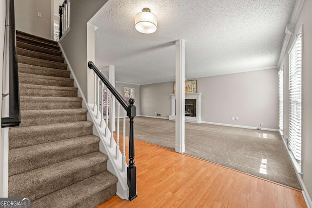 foyer with wood-type flooring, a textured ceiling, and a wealth of natural light