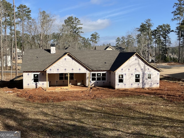 back of house featuring a lawn and a patio area