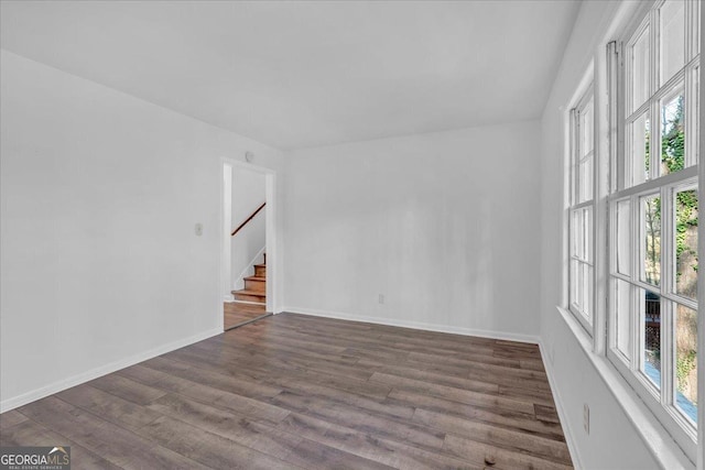 empty room featuring dark hardwood / wood-style flooring and a healthy amount of sunlight