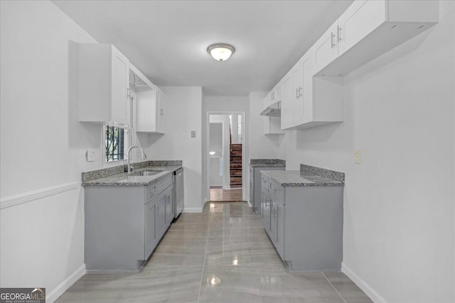 kitchen with gray cabinetry, sink, stainless steel appliances, light stone counters, and white cabinets