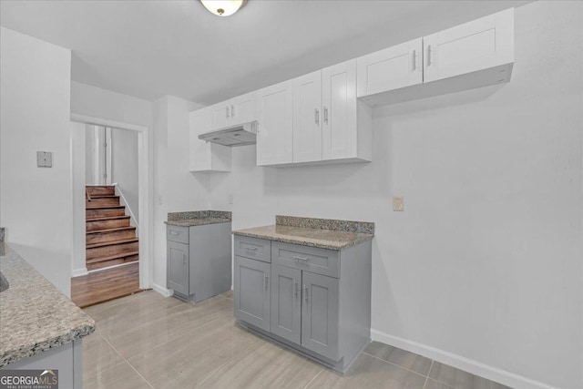 kitchen featuring ventilation hood, white cabinetry, gray cabinetry, and light tile patterned flooring