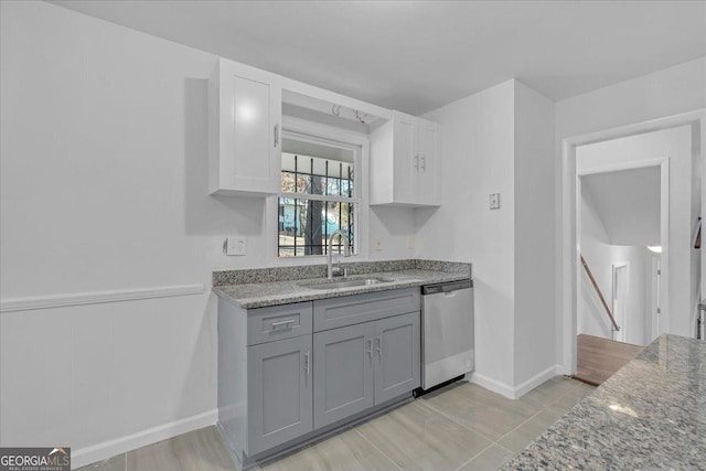 kitchen with dishwasher, white cabinets, sink, gray cabinets, and light stone counters