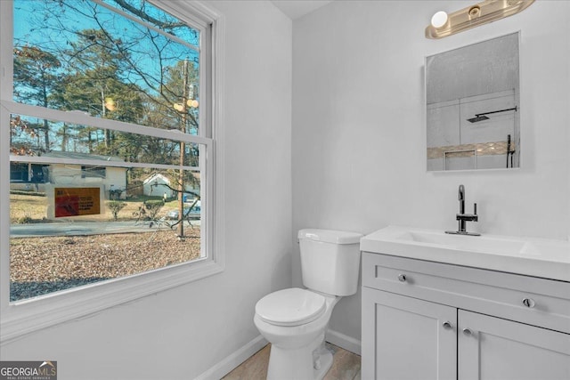 bathroom with vanity, toilet, and a wealth of natural light