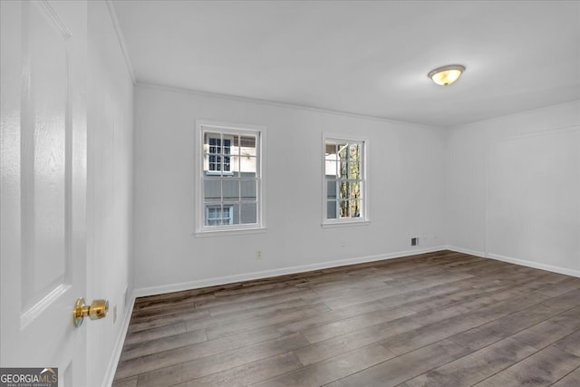 empty room featuring hardwood / wood-style flooring and crown molding